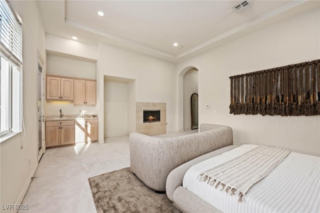 8712 Mesa Canogo Dr, Las Vegas, NV 89148 - bedroom with arched walkways, light colored carpet, multiple windows, recessed lighting, and a high end fireplace