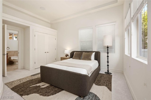 8712 Mesa Canogo Dr, Las Vegas, NV 89148 - bedroom featuring multiple windows, light colored carpet, a closet, and ensuite bath