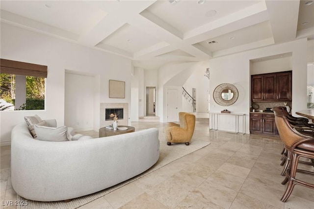 8712 Mesa Canogo Dr, Las Vegas, NV 89148 - living area with coffered ceiling, a glass covered fireplace, stairs, beamed ceiling, and a high ceiling