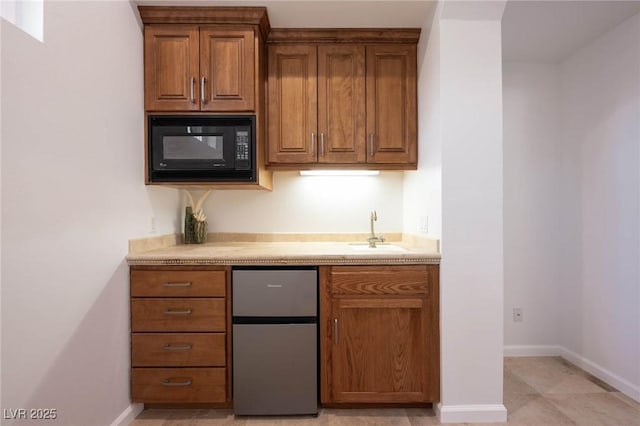 8712 Mesa Canogo Dr, Las Vegas, NV 89148 - kitchen with freestanding refrigerator, black microwave, and brown cabinets