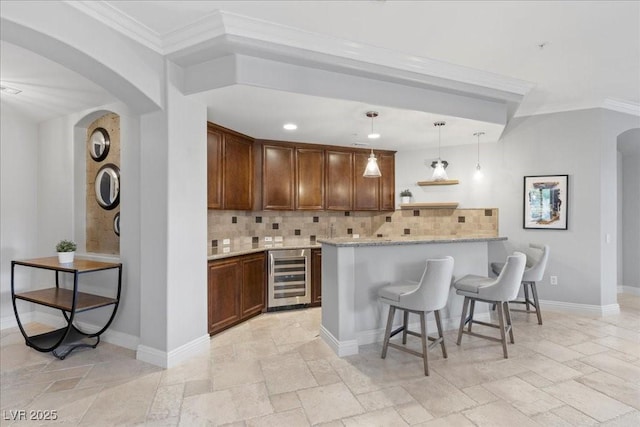 30 Via Mantova Unit 202, Henderson, NV 89011 - bar featuring beverage cooler, stone tile flooring, arched walkways, ornamental molding, and decorative backsplash