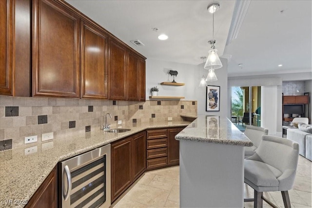 30 Via Mantova Unit 202, Henderson, NV 89011 - kitchen with wine cooler, a breakfast bar, open floor plan, light stone counters, and backsplash