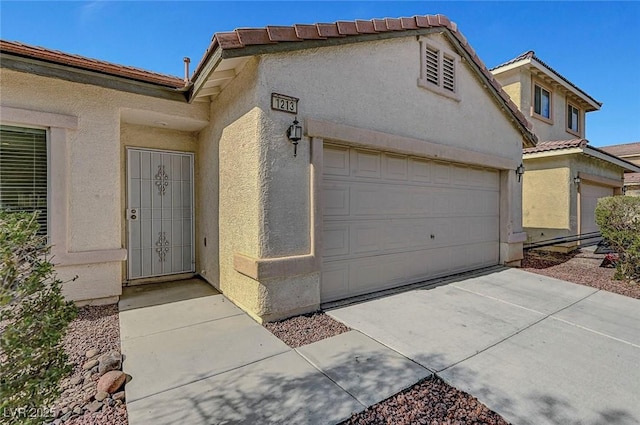 1213 Bistro Bay Ave, North Las Vegas, NV 89086 - entrance to property featuring stucco siding, a garage, and concrete driveway
