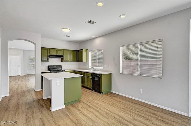 1213 Bistro Bay Ave, North Las Vegas, NV 89086 - kitchen with green cabinets, black appliances, arched walkways, light countertops, and a kitchen island