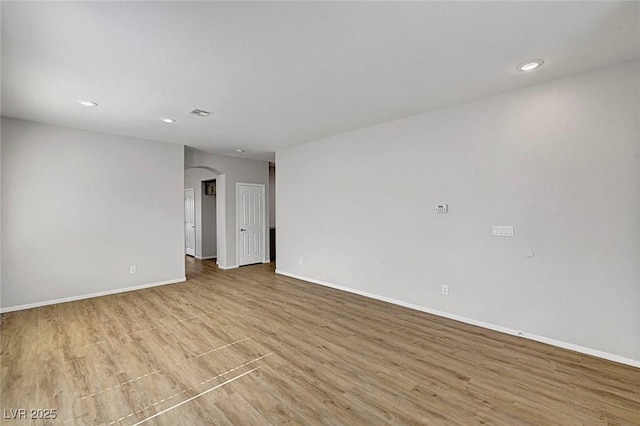 1213 Bistro Bay Ave, North Las Vegas, NV 89086 - empty room featuring arched walkways, wood finished floors, and recessed lighting