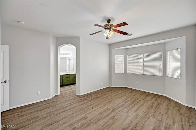 1213 Bistro Bay Ave, North Las Vegas, NV 89086 - empty room featuring ceiling fan, arched walkways, light wood-style flooring, and a smoke detector