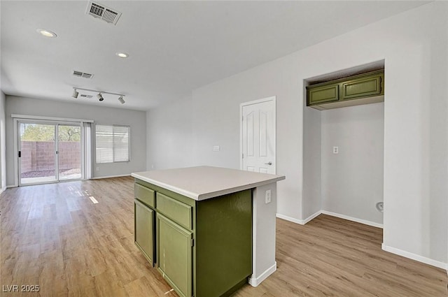 1213 Bistro Bay Ave, North Las Vegas, NV 89086 - kitchen featuring green cabinets, light wood-style floors, light countertops, a center island, and recessed lighting