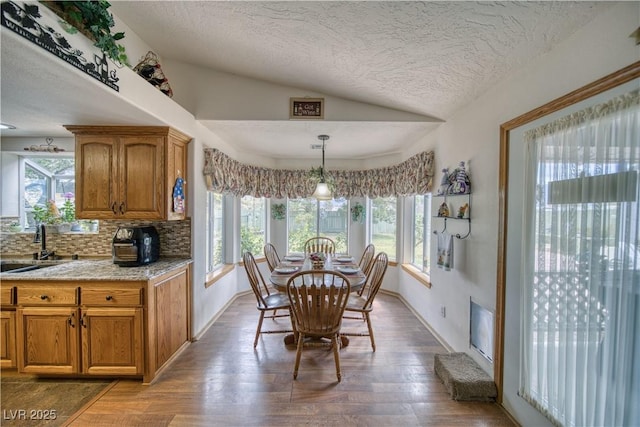 2910 Sunset St, Pahrump, NV 89060 - dining room featuring lofted ceiling, a textured ceiling, and wood finished floors