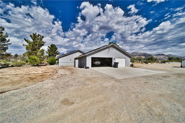 2910 Sunset St, Pahrump, NV 89060 - view of side of home with a mountain view, stucco siding, and driveway