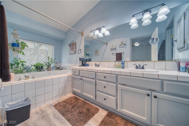 2910 Sunset St, Pahrump, NV 89060 - bathroom with double vanity, a garden tub, lofted ceiling, and wood finished floors