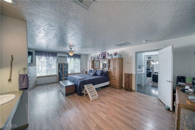 2910 Sunset St, Pahrump, NV 89060 - bedroom featuring light wood-style flooring, a textured ceiling, and ceiling fan