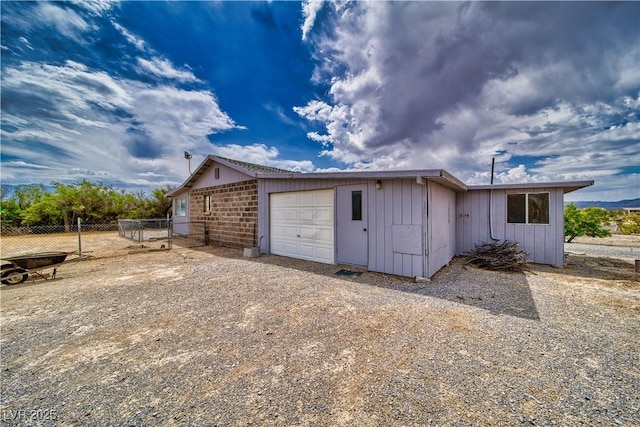 2910 Sunset St, Pahrump, NV 89060 - view of home's exterior with an attached garage, brick siding, and dirt driveway
