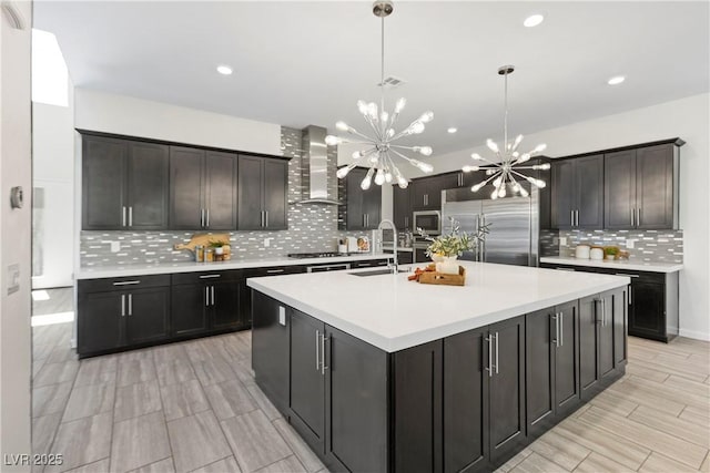 6234 Amber View St, Las Vegas, NV 89135 - kitchen with wall chimney exhaust hood, stainless steel appliances, a chandelier, decorative backsplash, and light countertops