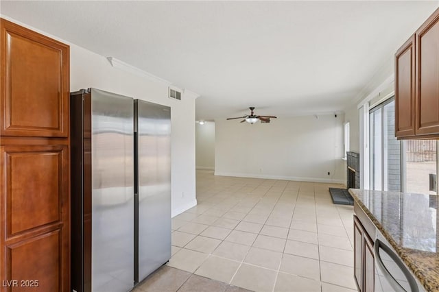 7000 Paddington Way, Las Vegas, NV 89147 - kitchen with freestanding refrigerator, ceiling fan, dark stone counters, light tile patterned flooring, and brown cabinets