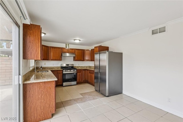 7000 Paddington Way, Las Vegas, NV 89147 - kitchen with appliances with stainless steel finishes, under cabinet range hood, light stone counters, brown cabinets, and light tile patterned floors