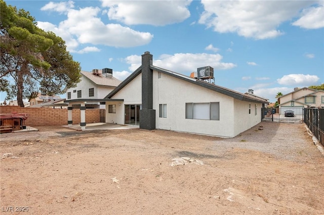 7000 Paddington Way, Las Vegas, NV 89147 - back of property with a patio area, a fenced backyard, a chimney, and stucco siding