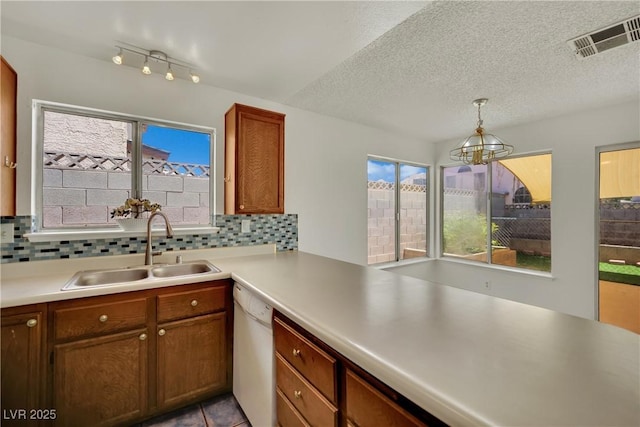 1676 Divinity St, Las Vegas, NV 89142 - kitchen featuring dishwasher, plenty of natural light, tasteful backsplash, a chandelier, and a textured ceiling