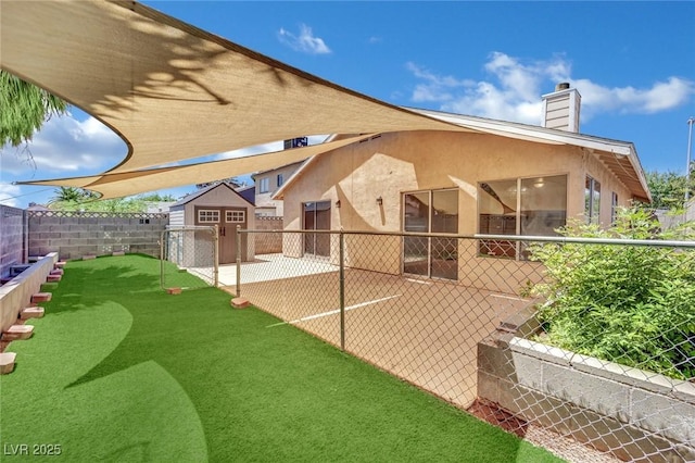 1676 Divinity St, Las Vegas, NV 89142 - back of property featuring stucco siding, a patio area, a shed, and a fenced backyard