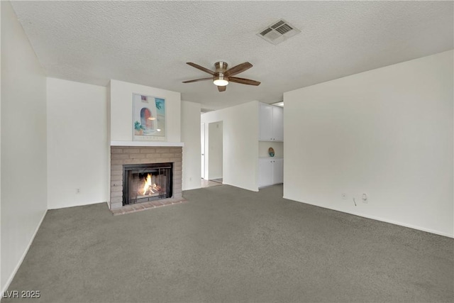 1676 Divinity St, Las Vegas, NV 89142 - unfurnished living room with a brick fireplace, a ceiling fan, carpet floors, and a textured ceiling