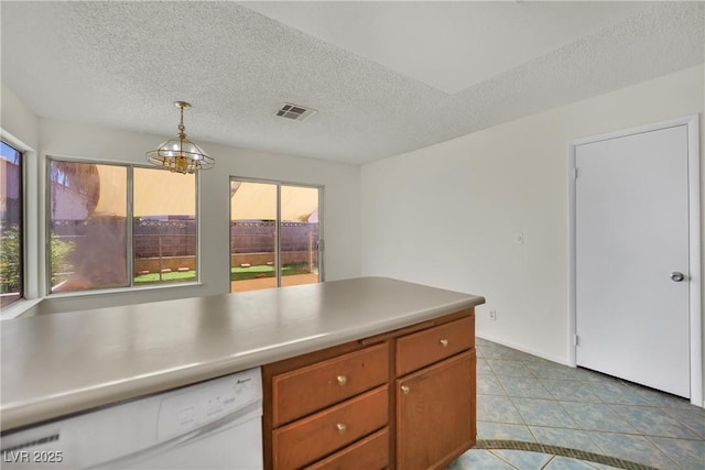 1676 Divinity St, Las Vegas, NV 89142 - kitchen featuring white dishwasher, a textured ceiling, hanging light fixtures, a chandelier, and tile patterned flooring