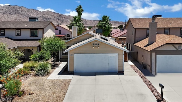 1676 Divinity St, Las Vegas, NV 89142 - view of front facade with concrete driveway, a mountain view, and a residential view