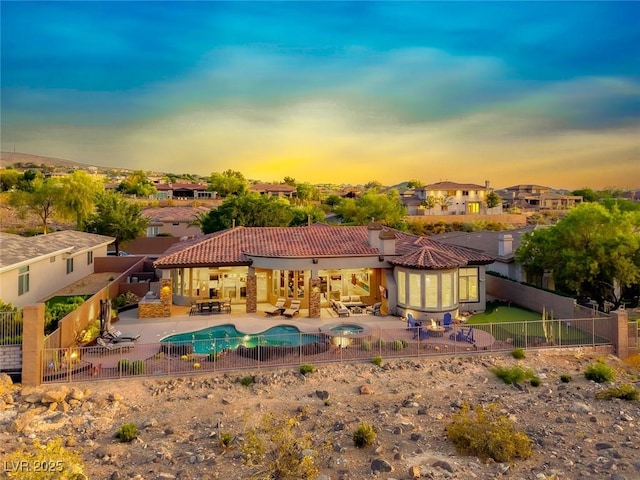 22 Starbrook Dr, Henderson, NV 89052 - back of property at dusk with a fenced backyard, a patio, a tiled roof, an outdoor hangout area, and a residential view
