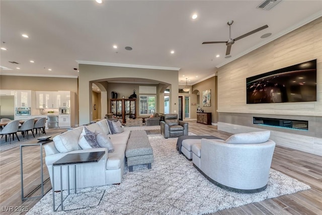 22 Starbrook Dr, Henderson, NV 89052 - living room featuring arched walkways, crown molding, a ceiling fan, wood finished floors, and recessed lighting