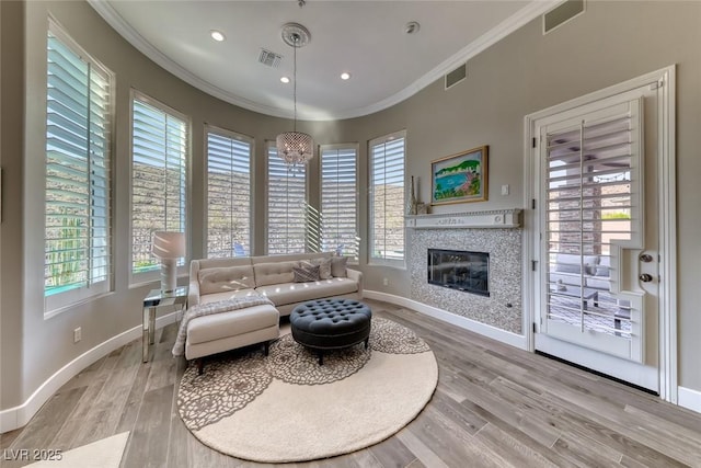 22 Starbrook Dr, Henderson, NV 89052 - living area featuring crown molding, plenty of natural light, a glass covered fireplace, light wood-style floors, and recessed lighting
