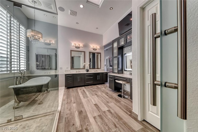 22 Starbrook Dr, Henderson, NV 89052 - full bath with vanity, a soaking tub, wood finished floors, and healthy amount of natural light
