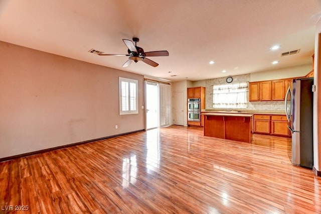 6720 Sand Swallow St, North Las Vegas, NV 89084 - kitchen featuring appliances with stainless steel finishes, open floor plan, healthy amount of natural light, brown cabinets, and recessed lighting