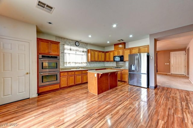 6720 Sand Swallow St, North Las Vegas, NV 89084 - kitchen with stainless steel appliances, light countertops, backsplash, brown cabinets, and recessed lighting