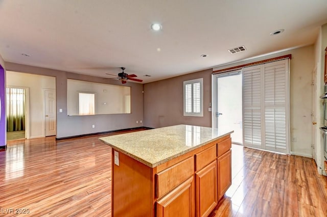 6720 Sand Swallow St, North Las Vegas, NV 89084 - kitchen featuring light wood-style flooring, a center island, ceiling fan, recessed lighting, and brown cabinetry
