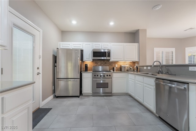 1641 Dark Wolf Ave, Las Vegas, NV 89123 - kitchen with appliances with stainless steel finishes, backsplash, white cabinetry, light tile patterned flooring, and recessed lighting