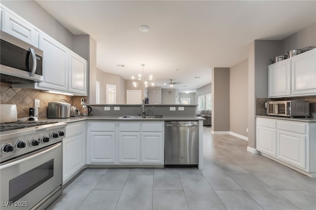 1641 Dark Wolf Ave, Las Vegas, NV 89123 - kitchen featuring stainless steel appliances, a peninsula, tasteful backsplash, a chandelier, and white cabinets
