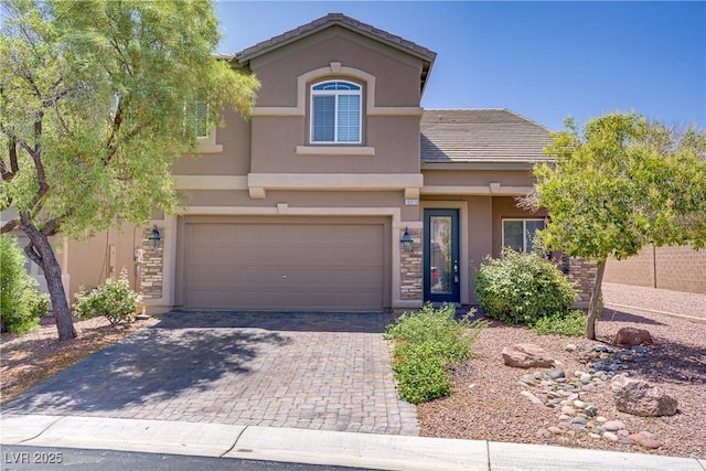 10015 Willowbrook Pond Rd, Las Vegas, NV 89148 - view of front of home with stucco siding, decorative driveway, an attached garage, a tile roof, and stone siding