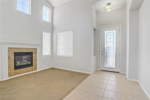 10015 Willowbrook Pond Rd, Las Vegas, NV 89148 - tiled entryway featuring a glass covered fireplace, carpet flooring, and a high ceiling