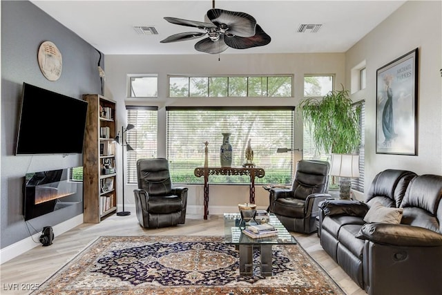 2832 Castle Bar Dr, Las Vegas, NV 89134 - living area with ceiling fan, plenty of natural light, wood finished floors, and a glass covered fireplace