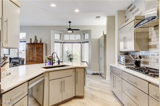 2832 Castle Bar Dr, Las Vegas, NV 89134 - kitchen with stainless steel appliances, exhaust hood, ceiling fan, tasteful backsplash, and light wood finished floors