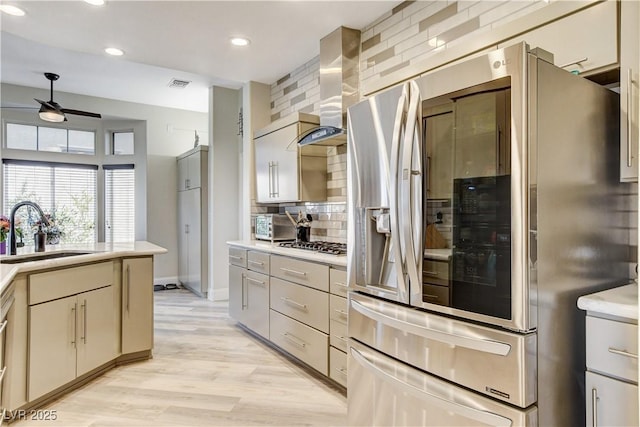 2832 Castle Bar Dr, Las Vegas, NV 89134 - kitchen with stainless steel appliances, wall chimney range hood, decorative backsplash, a ceiling fan, and light countertops