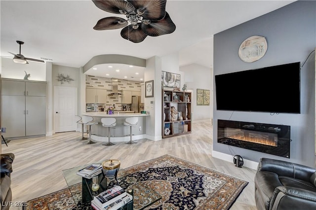 2832 Castle Bar Dr, Las Vegas, NV 89134 - living area with ceiling fan, light wood finished floors, and a glass covered fireplace