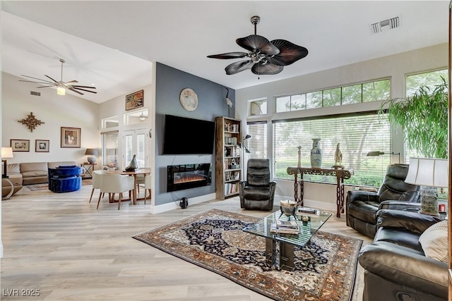 2832 Castle Bar Dr, Las Vegas, NV 89134 - living room featuring a ceiling fan, a glass covered fireplace, and wood finished floors
