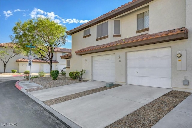 917 Intrigue Way, Las Vegas, NV 89128 - view of front of property featuring a tiled roof, an attached garage, concrete driveway, and stucco siding