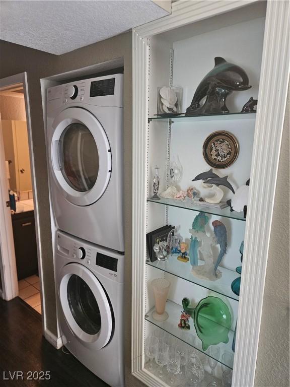 1341 Del Mar St Unit 101, Las Vegas, NV 89119 - laundry area with stacked washer / drying machine and dark wood-type flooring