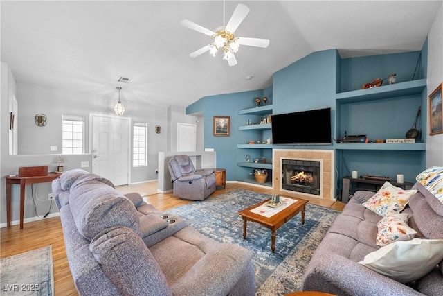 200 E Domingo St, Pahrump, NV 89048 - living room with built in features, vaulted ceiling, a ceiling fan, wood finished floors, and a fireplace