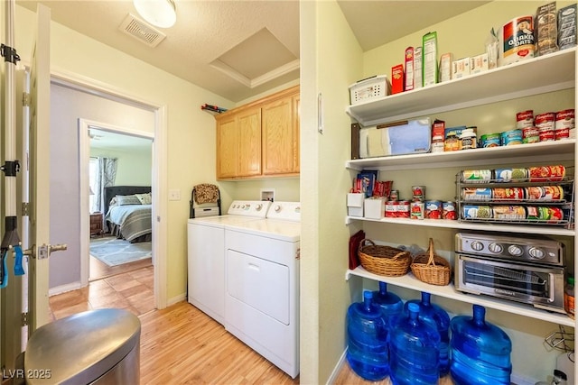 200 E Domingo St, Pahrump, NV 89048 - laundry room featuring cabinet space, separate washer and dryer, light wood-type flooring, and attic access