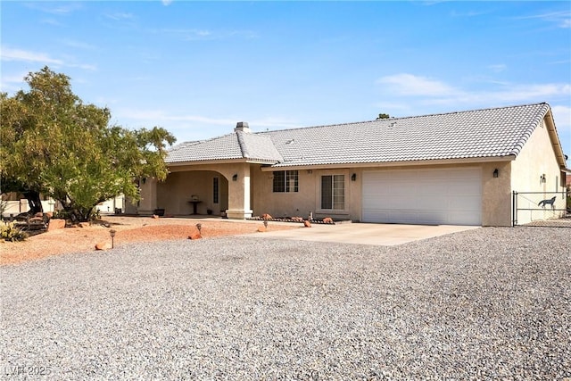 200 E Domingo St, Pahrump, NV 89048 - single story home with stucco siding, driveway, a garage, a tiled roof, and a chimney