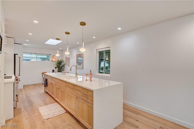 3022 El Camino Ave, Las Vegas, NV 89102 - kitchen with a skylight, light wood-style floors, a kitchen island with sink, light brown cabinets, and recessed lighting