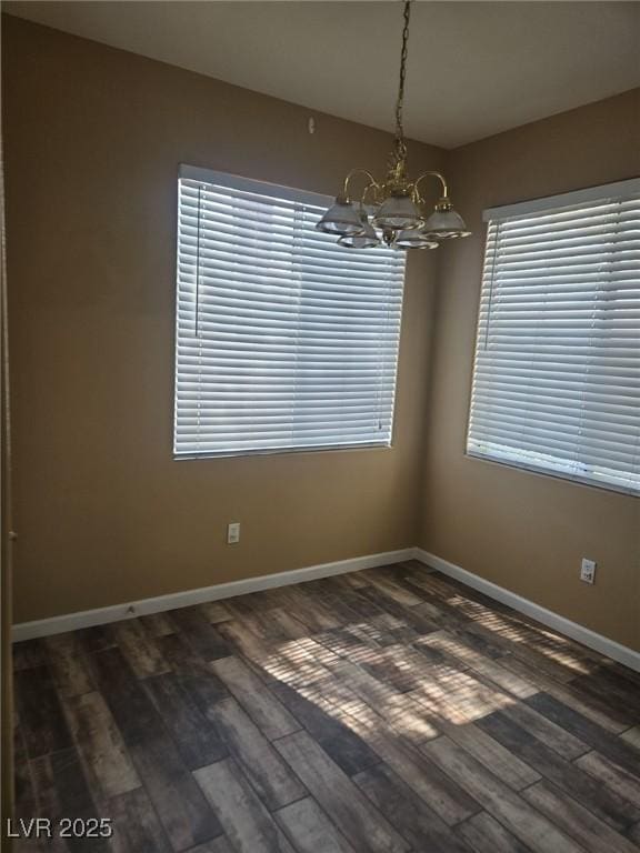 9050 W Warm Springs Rd Unit 1128, Las Vegas, NV 89148 - spare room with a chandelier, dark wood-style floors, and healthy amount of natural light