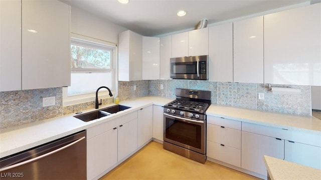 1518 Golden Arrow Dr, Las Vegas, NV 89169 - kitchen featuring stainless steel appliances, modern cabinets, light countertops, tasteful backsplash, and white cabinetry