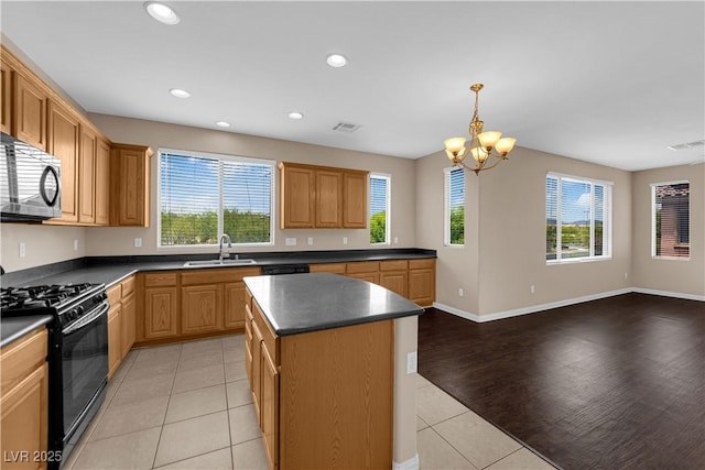 9489 Country Highlands Ct, Las Vegas, NV 89178 - kitchen with black appliances, a chandelier, light tile patterned floors, dark countertops, and open floor plan
